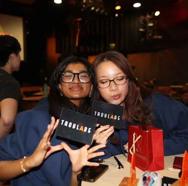 Two members posing with TroyLabs gift bags